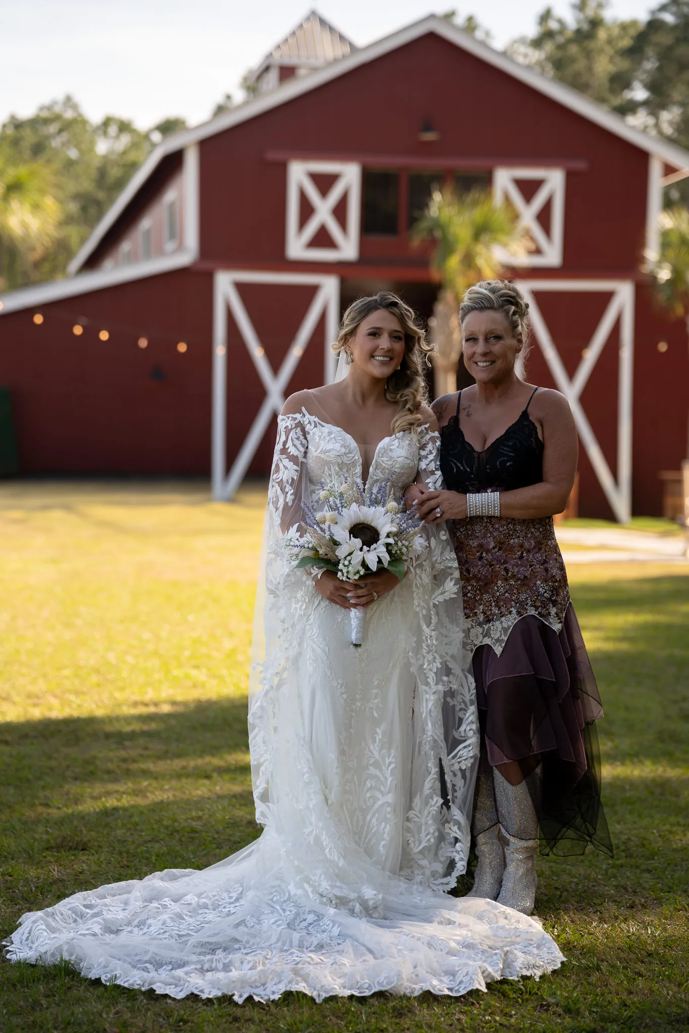 Bride Riley with friend in front of red barn at Tringali Barn