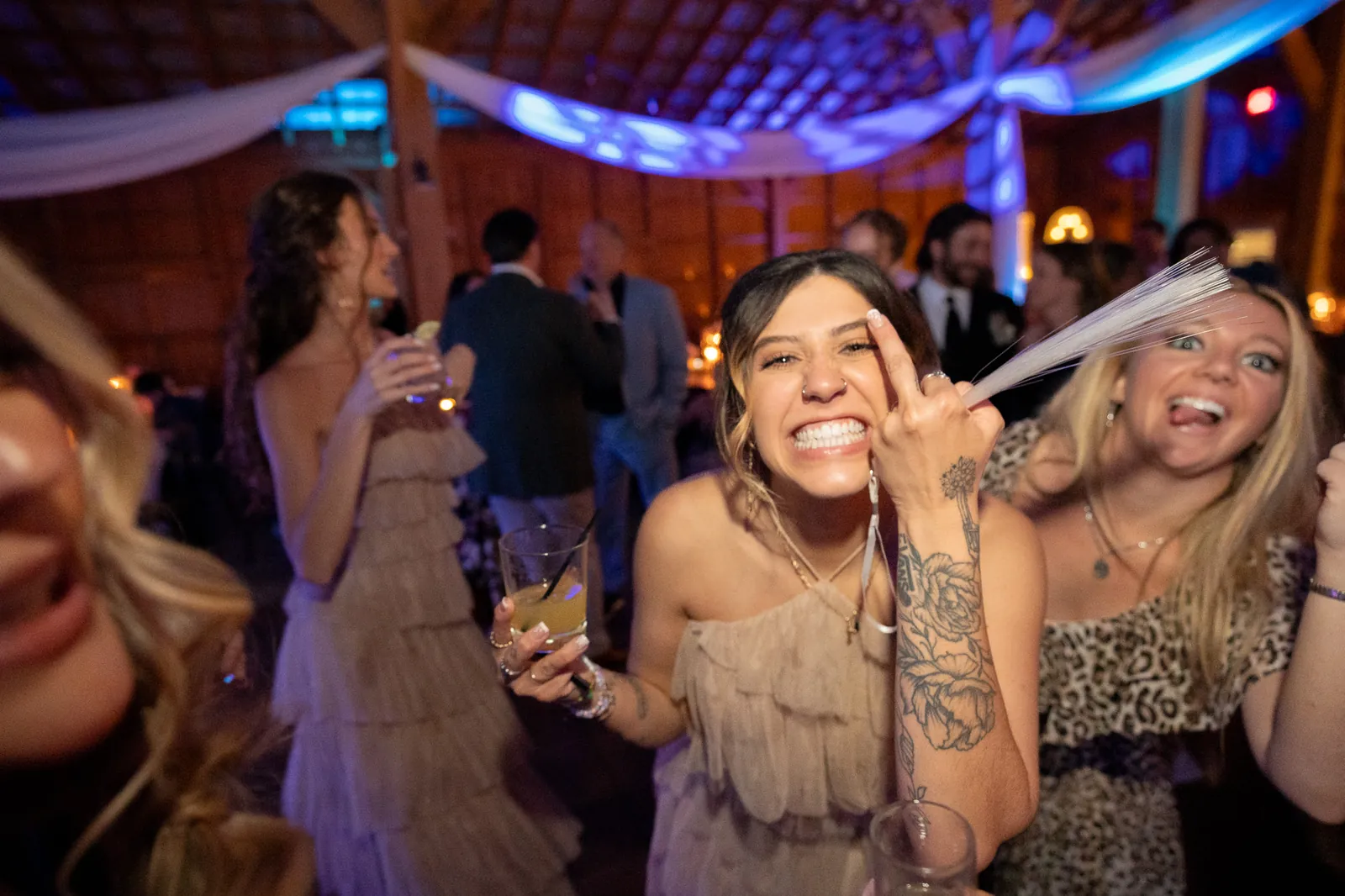 Bridesmaid dancing with glow sticks at party at Tringali Barn