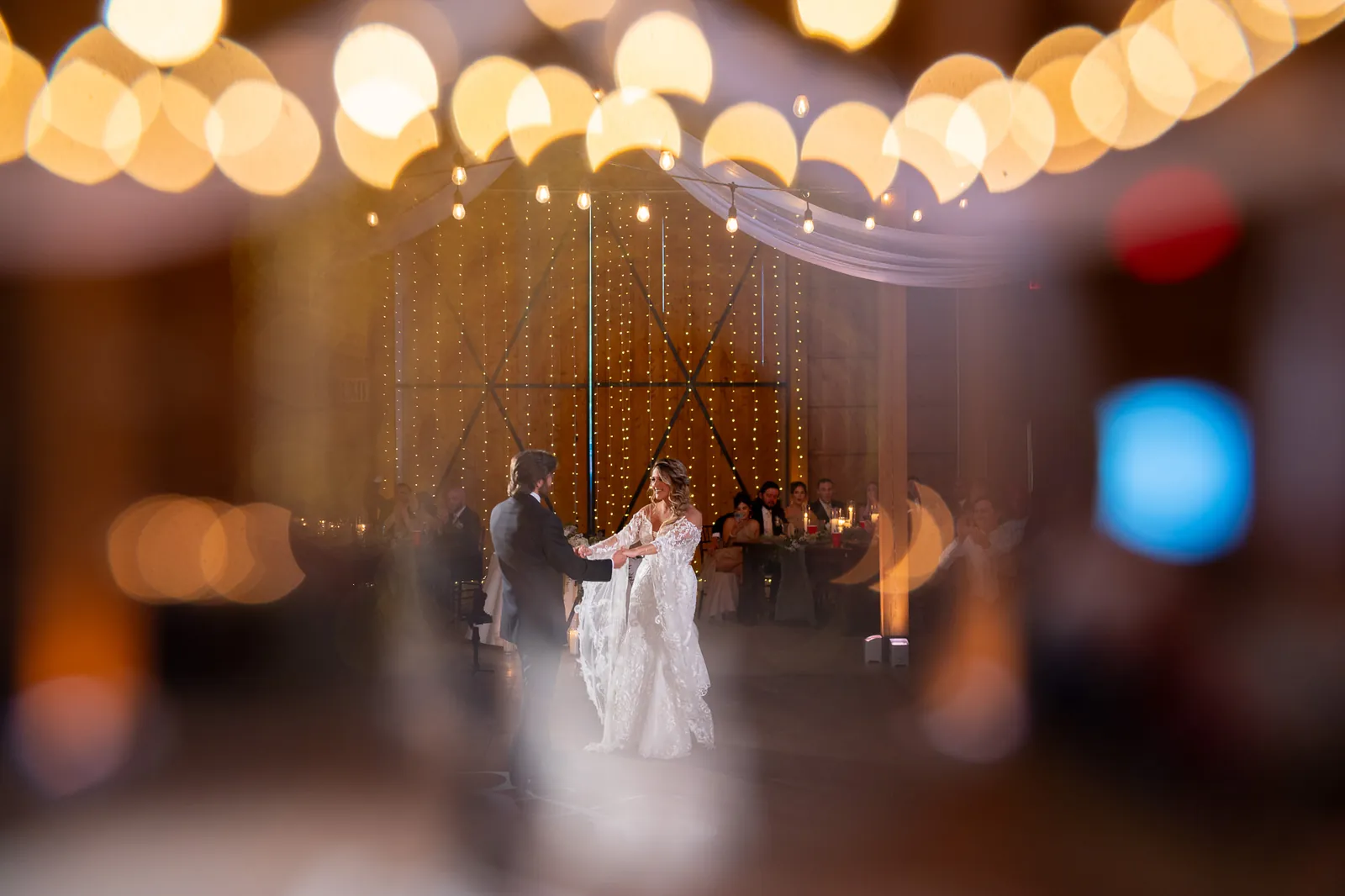First dance with barn doors and fairy lights backdrop at Tringali Barn