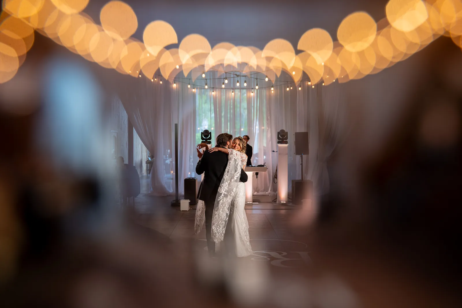 First dance with string lights bokeh inside barn at Tringali Barn