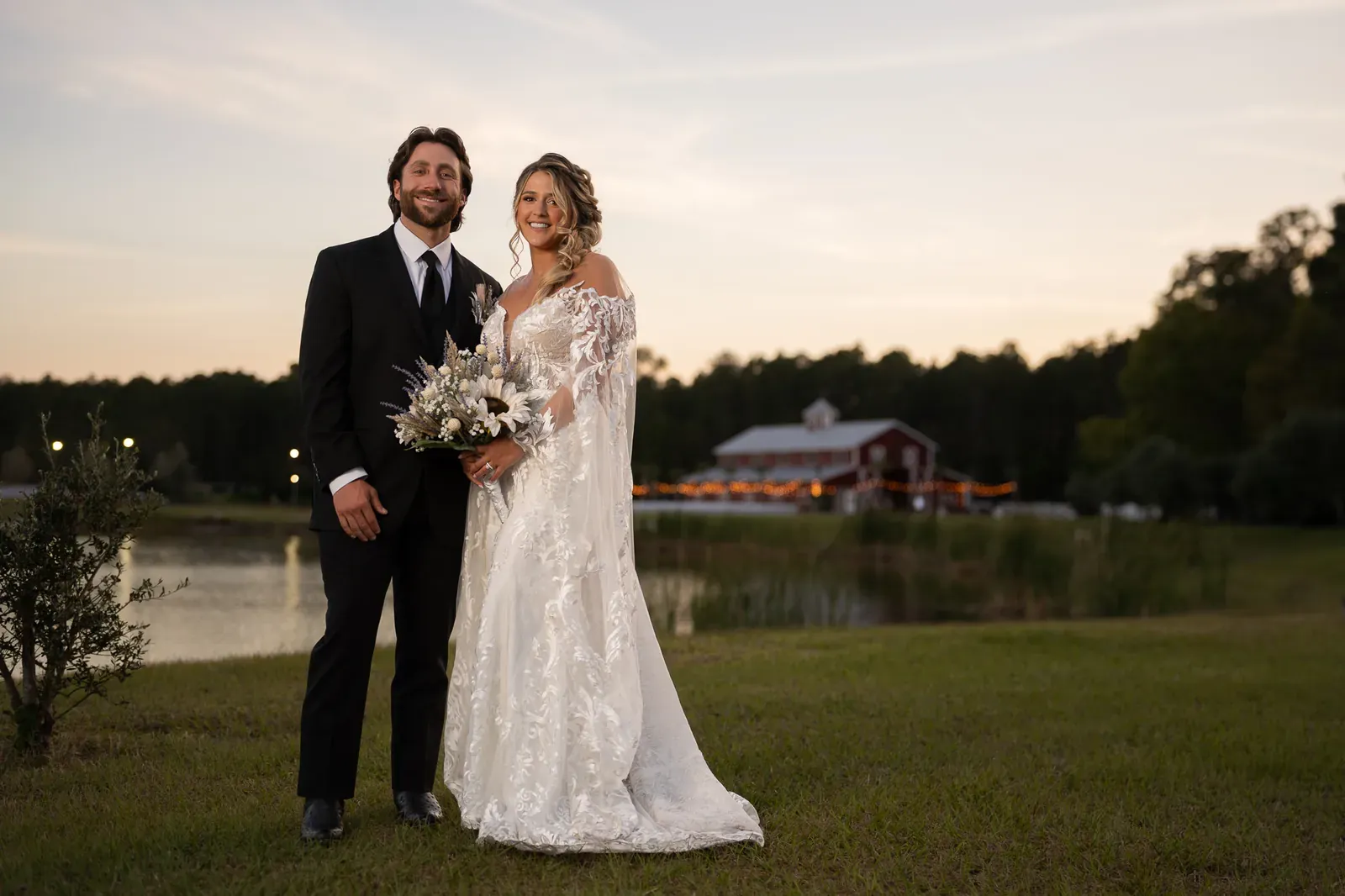 Riley and Robert portrait at dusk with lake and red barn at Tringali Barn in St. Augustine