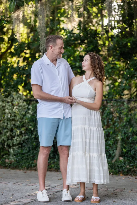 Daniel and Samantha hold hands beneath Spanish moss-draped oak trees on a shaded avenue in St. Augustine.