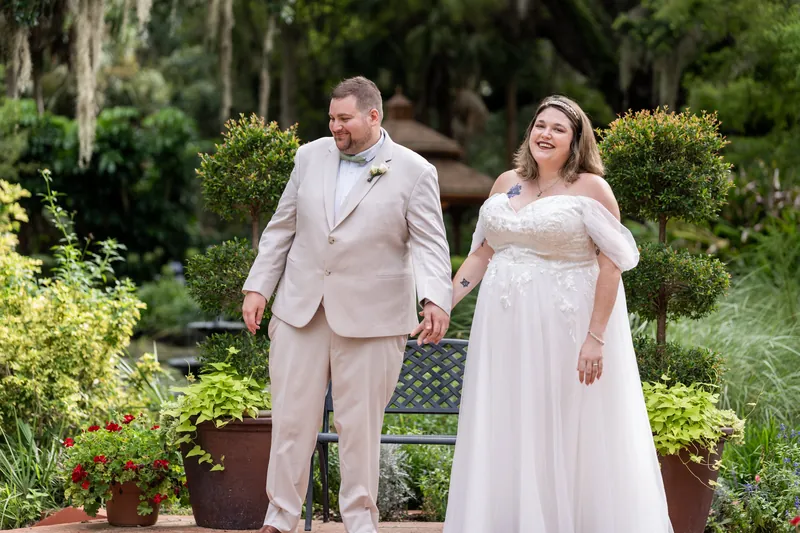 The couple walks together through the manicured gardens, Matthew in a beige suit and Samantha in an off-shoulder white gown.