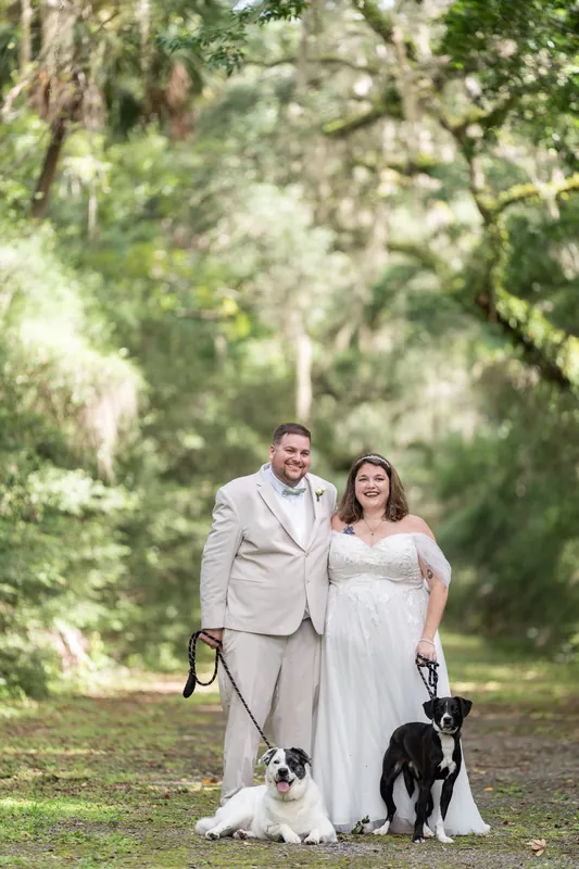 Samantha and Matthew walk through moss-hung oaks with their black dog at Washington Oaks Gardens State Park.