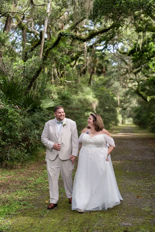 The couple strolls down a shaded path lined with ancient oaks at Washington Oaks Gardens State Park.
