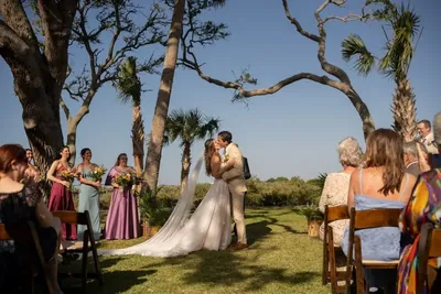 First kiss at outdoor ceremony under palm trees at Fountain of Youth with marsh backdrop