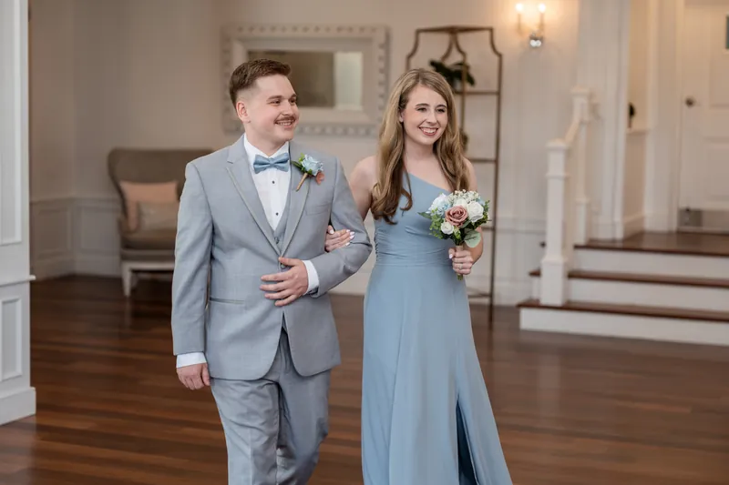 Sarah and Nathan stroll together at The White Room, Nathan in his light blue suit and Sarah in her flowing blue dress
