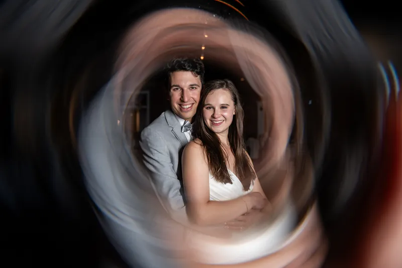 Sarah and Nathan smile together, framed by a circular motion blur effect during their first dance.