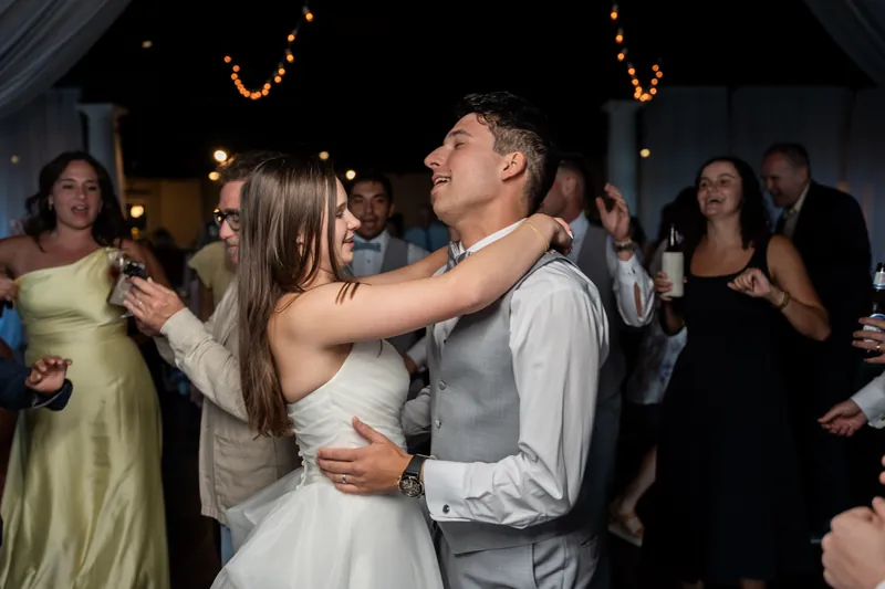 Sarah Katherine and Nathan dance together during their reception, with guests watching from the surrounding dance floor.
