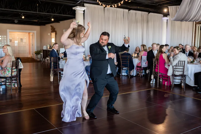 Sarah and Tim dance together at The White Room, with Sarah in a lavender gown and Tim in a dark suit as guests watch