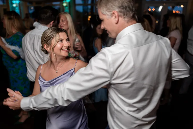 Sarah and a man in a light shirt dance together at The White Room, guests blurred behind them.