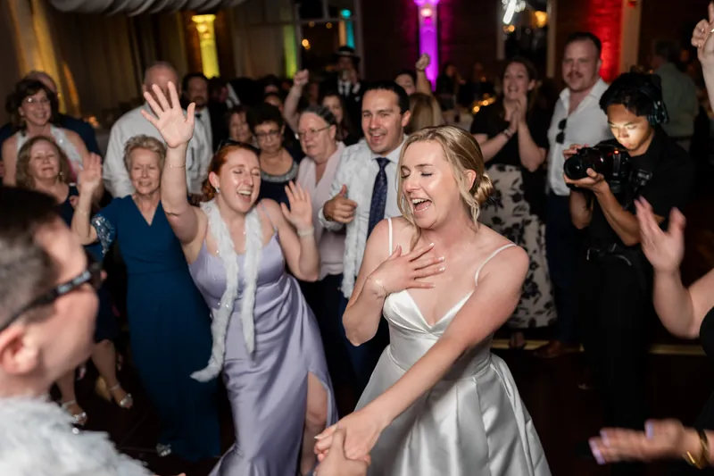 Sarah spins joyfully surrounded by dancing guests throughout The White Room's crowded dance floor.