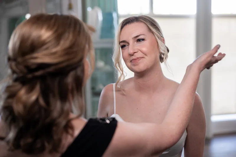 Sarah laughs while talking with a guest at The White Room, gesturing expressively during pre-ceremony preparations.