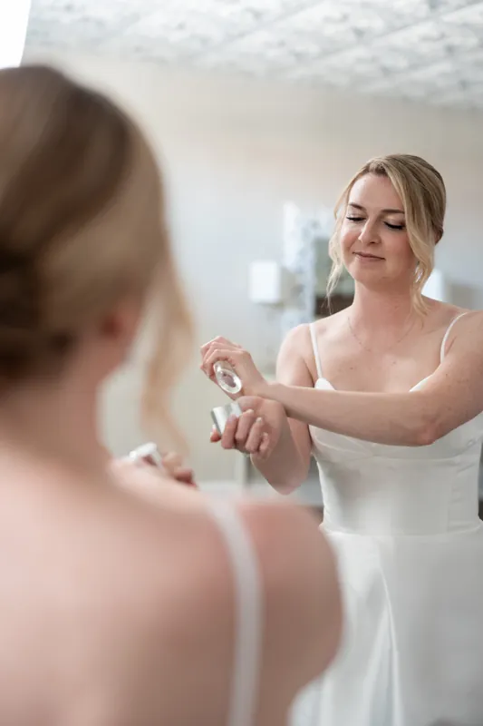 Sarah smiles while adjusting a bracelet on a woman's wrist at The White Room.