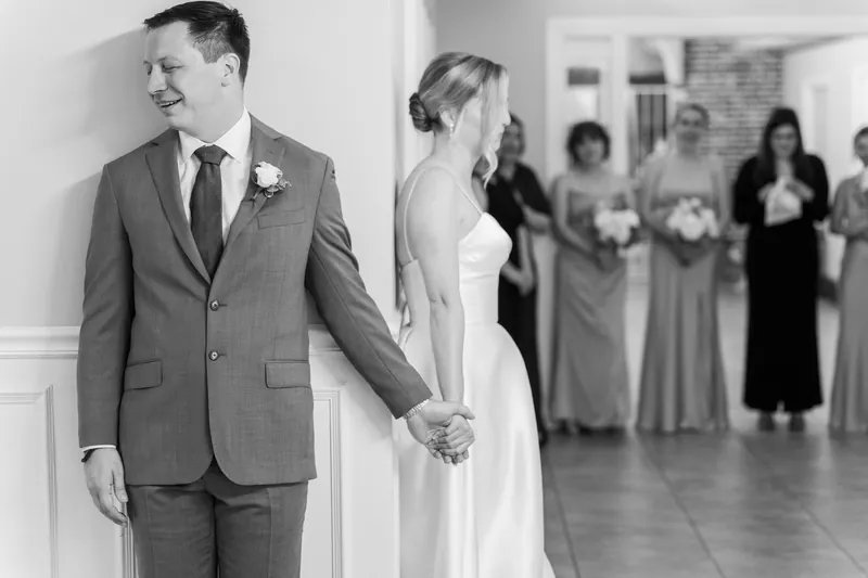 Sarah and Tim walk hand in hand past guests in the ceremony space, both smiling.