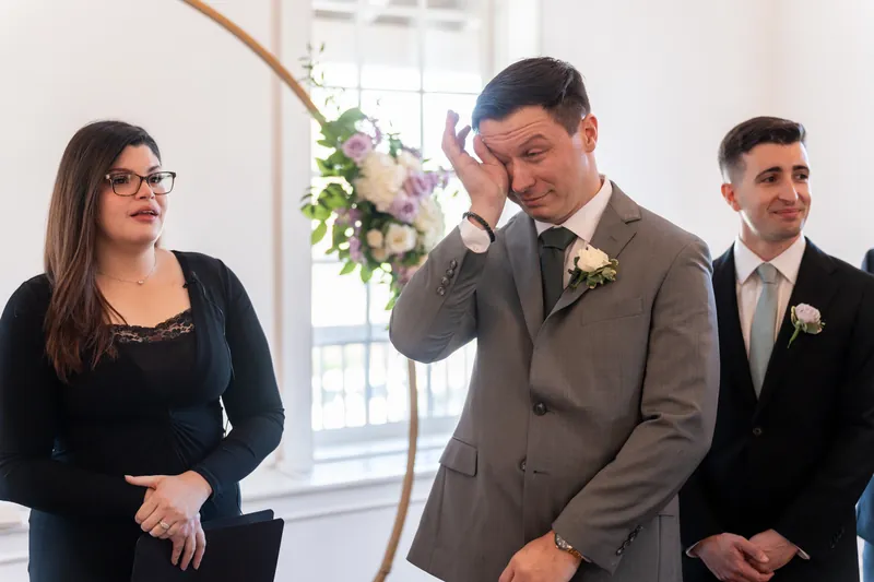 Tim closes his eyes with emotion while standing beside family members during the ceremony at Villa Blanca.