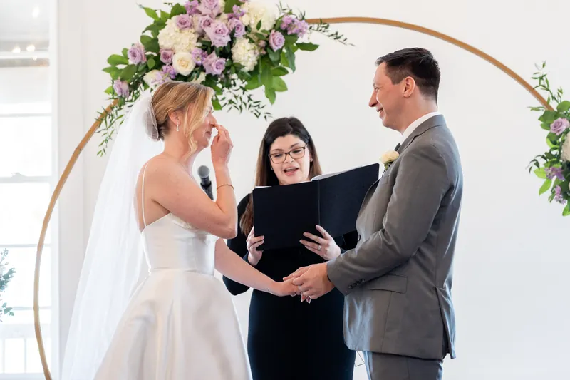 Sarah and Tim exchange vows beneath a floral arch as their officiant presides at Villa Blanca, St. Augustine.