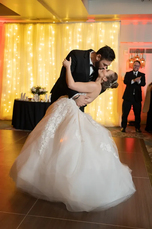 Michael dips Simone during their first dance beneath golden string lights at Casa Monica Resort & Spa.