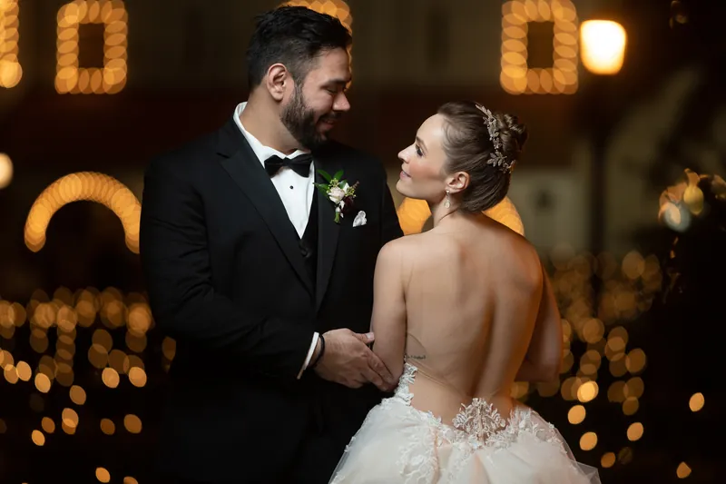 Simone and Michael face each other closely, glowing amber lights blurred behind them at Casa Monica Resort & Spa.
