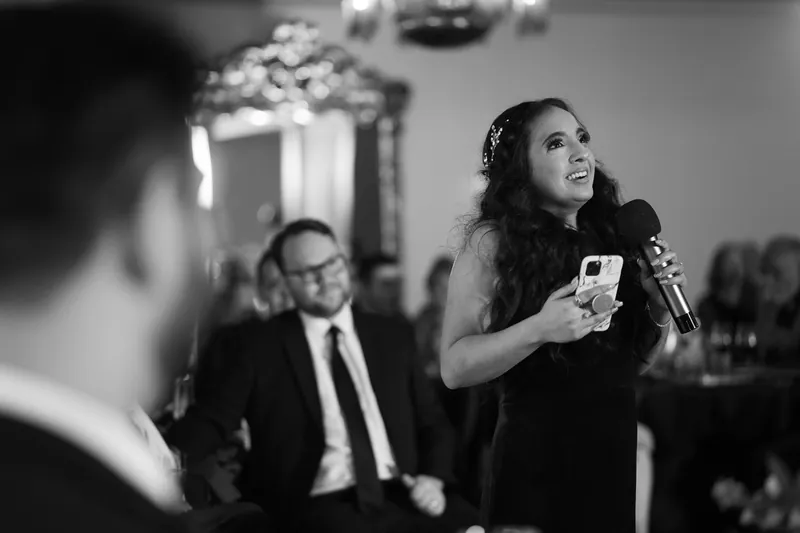 Simone speaks at the microphone during the reception while Michael listens nearby.