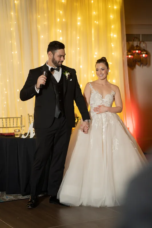 Michael speaks at the microphone while Simone stands beside him in her wedding dress at Casa Monica Resort & Spa.