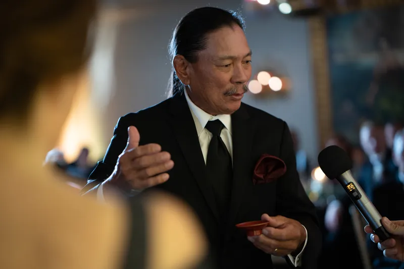 A guest delivers an animated toast, gesturing expressively at the reception.