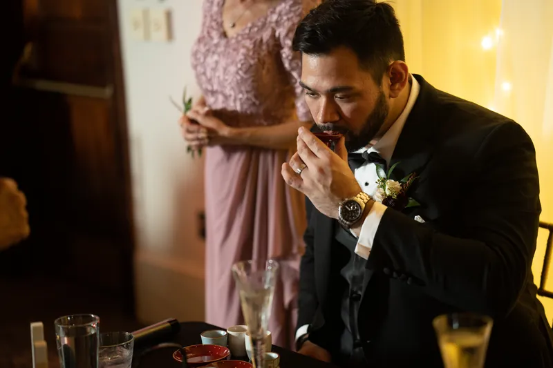 Michael closes his eyes and brings his hand to his mouth during a heartfelt moment at the reception.