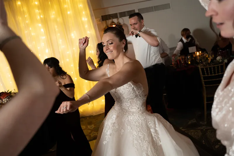 Simone dances with arms raised while guests watch under warm golden lighting at Casa Monica Resort & Spa.