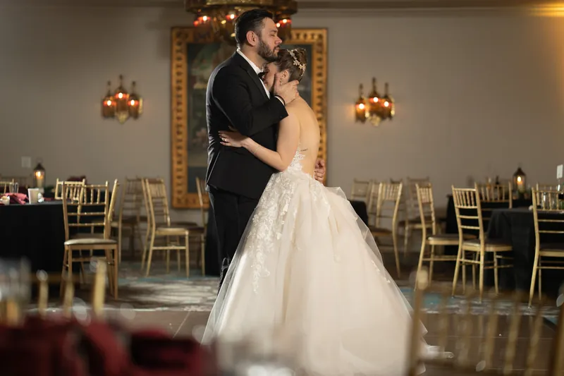 Michael and Simone share their first dance in the ballroom under ornate gold-framed mirrors.