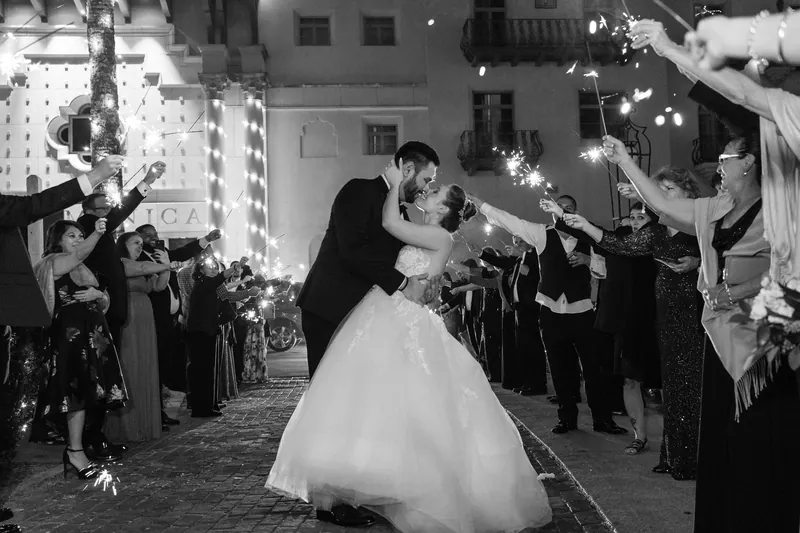 The couple dances together in a quiet moment surrounded by guests holding sparklers during their Casa Monica celebration.