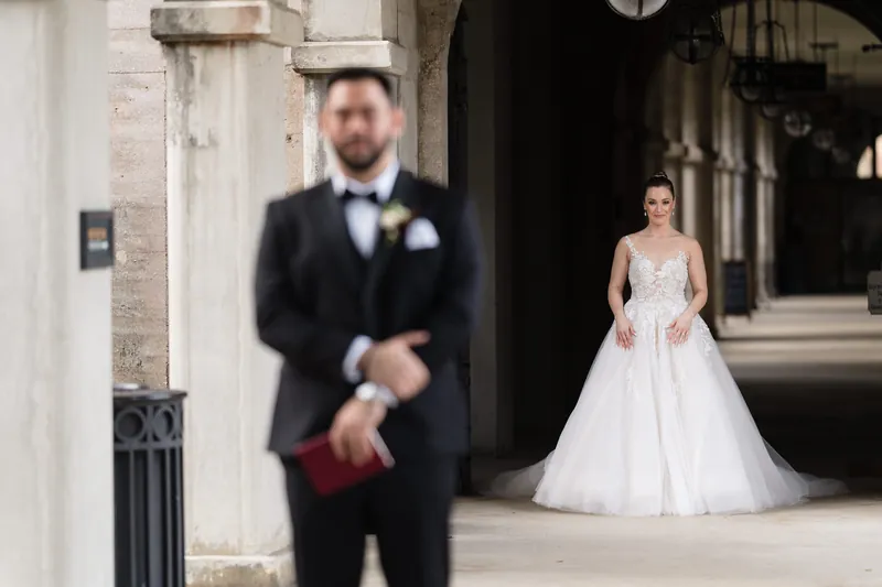 Simone walks toward Michael in her white ball gown as he stands in a black tuxedo at Casa Monica Resort & Spa.