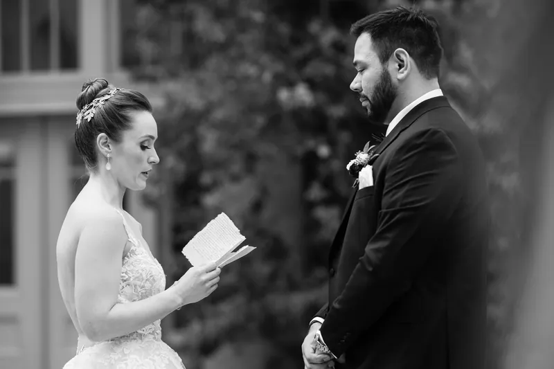 In black and white, Simone reads her vows to Michael as he watches intently at the resort's Spanish colonial courtyard.