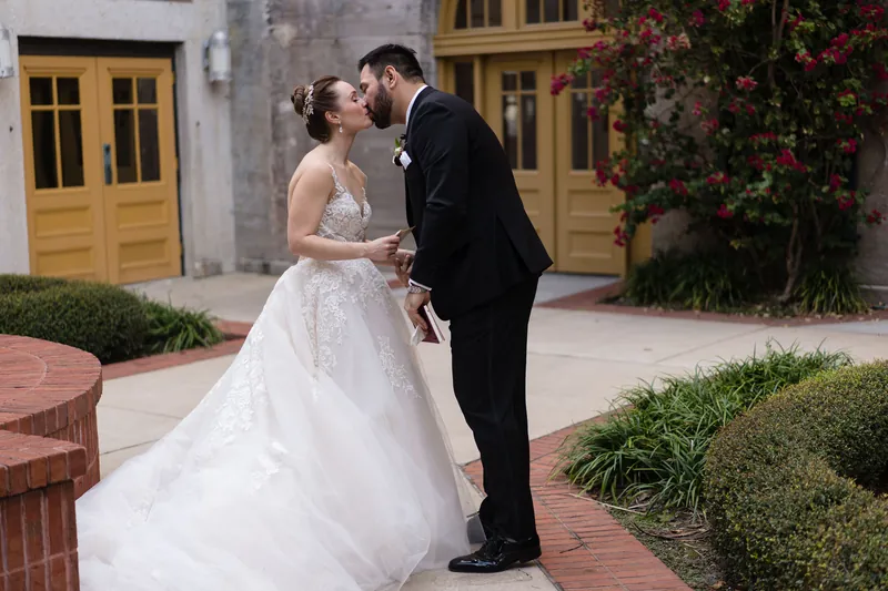 Michael kisses Simone in the courtyard at Casa Monica Resort & Spa, framed by golden doors and ivy.