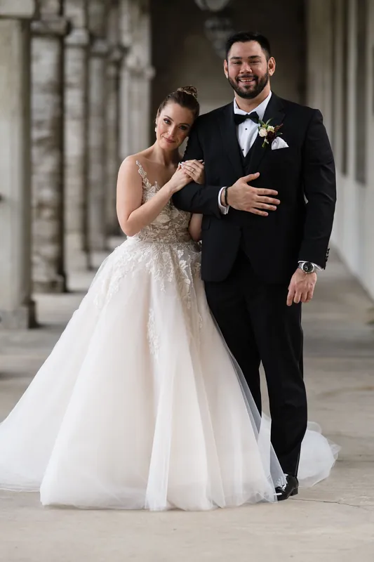 Michael and Simone walk arm-in-arm along the resort's covered archway, her train trailing gracefully behind them.