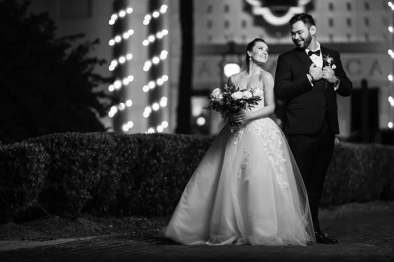 Simone and Michael stand together under glowing lights at Casa Monica Resort & Spa in a black and white portrait.