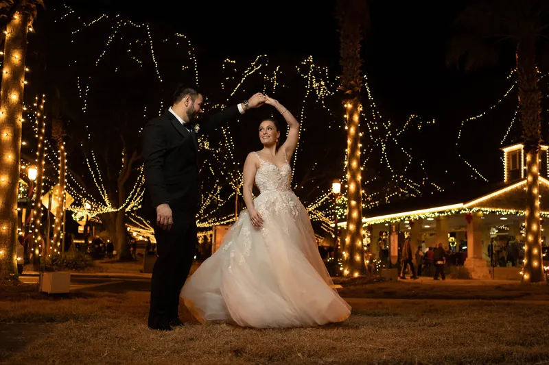 Michael twirls Simone under festive golden lights strung across the Casa Monica courtyard, her tulle gown billowing.