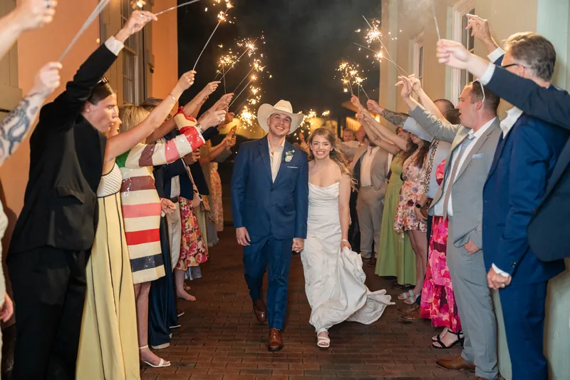 Skye and Elliot walk through a sparkler tunnel as guests celebrate at the White Room.