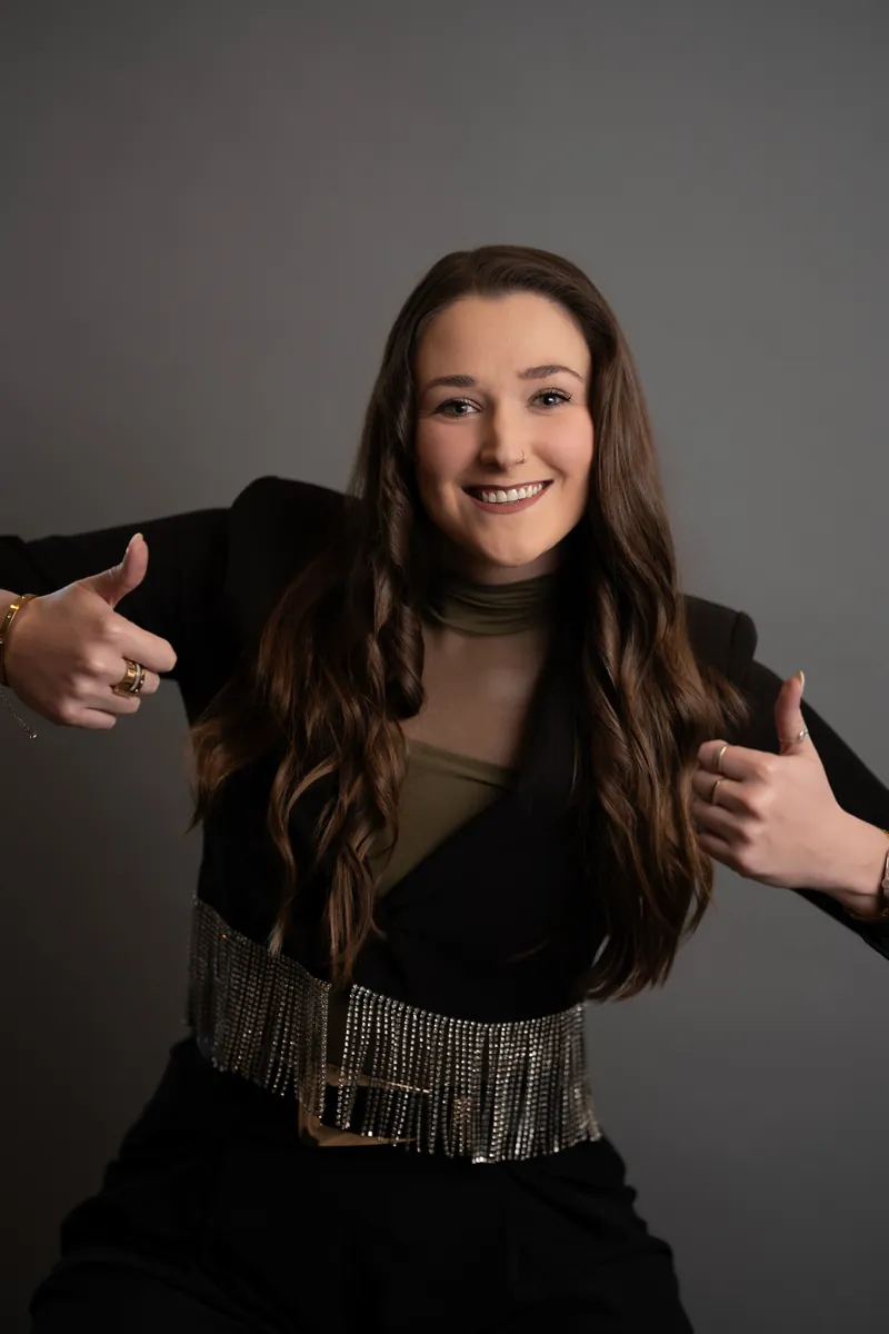 Professional headshot of woman in black blazer giving thumbs up