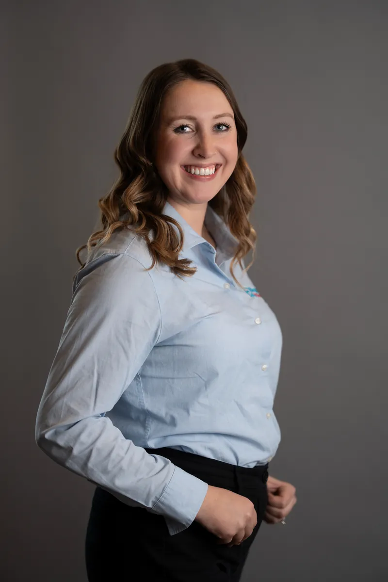 Professional headshot of woman in light blue button-up shirt