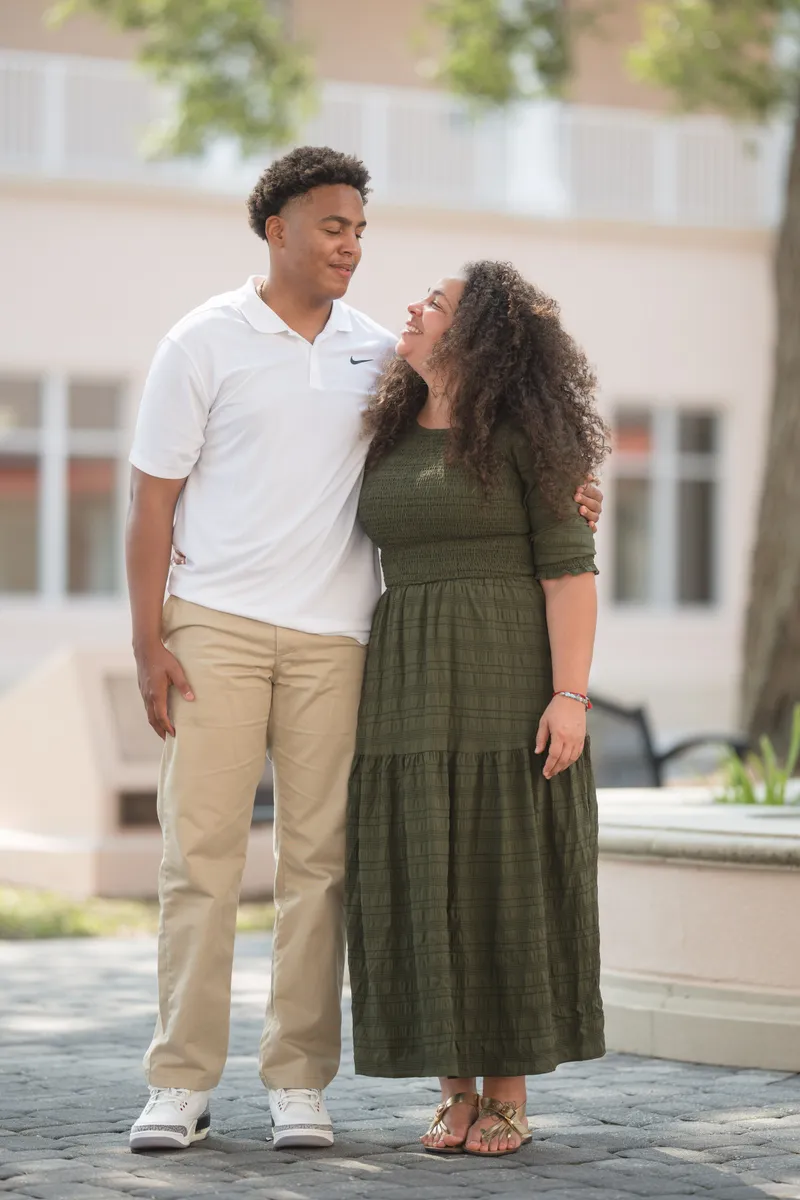 A joyful couple shares an intimate embrace and laughter during their courthouse elopement celebration in an urban courtyard setting.