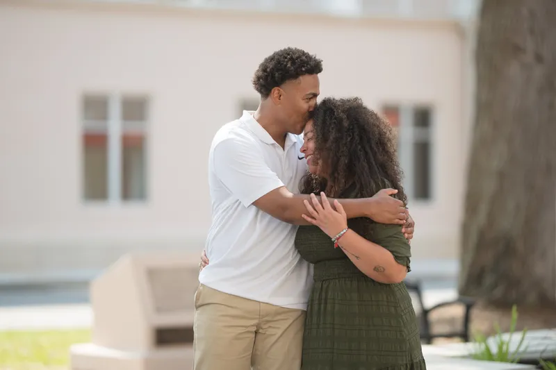 A couple shares an intimate embrace outside a courthouse building, celebrating their elopement with genuine joy and connection.