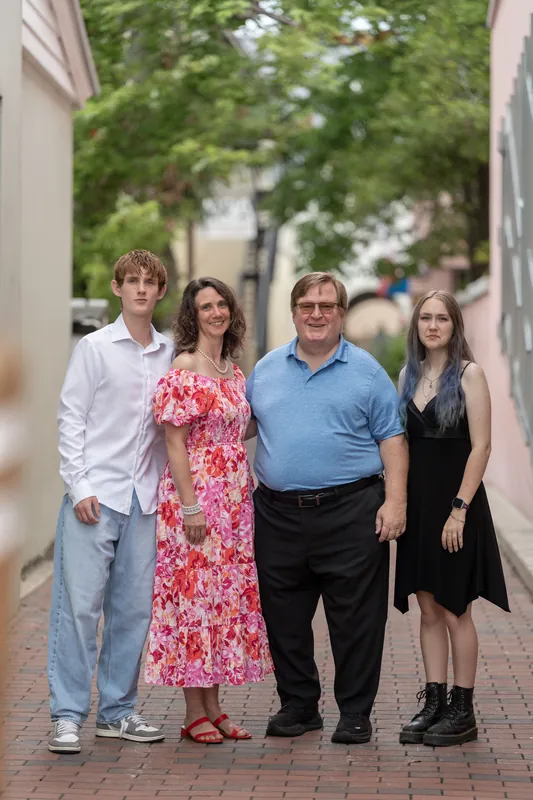 Spencer stands with his family on a brick street lined with historic buildings in Downtown St Augustine, all smiling