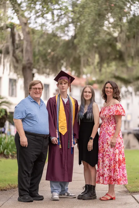 Spencer's family of four poses together on a tree-lined street in Downtown St Augustine.
