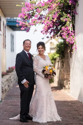 St. Augustine wedding photographer captures bride and groom under magenta flowers at Treasury on the Plaza