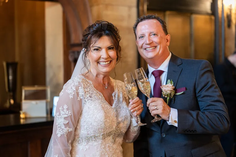 Stacy and Dean toast with champagne glasses, both smiling at the camera.