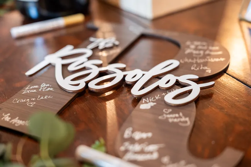 A white wooden "Keepsys" sign rests on brown kraft paper place cards on a wood table.