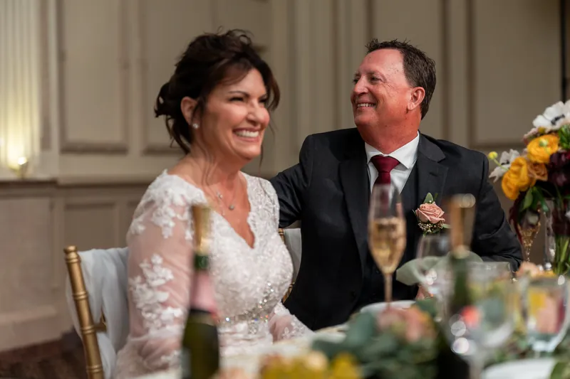 Stacy and Dean smile at each other during their reception at The Treasury on the Plaza, St. Augustine, surrounded