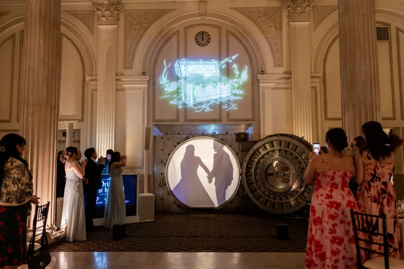 Guests gather to watch a large video projection and illuminated circular display during the evening celebration