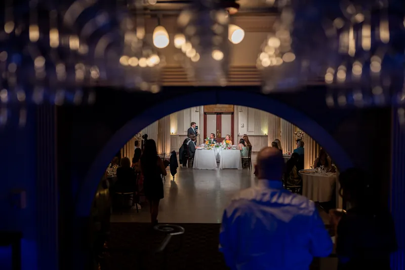 Guests look toward an illuminated archway leading into the ballroom at The Treasury on the Plaza.