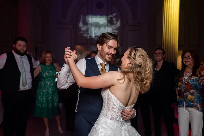 Chris and Sybil dance together at The Treasury on the Plaza while guests watch from the dimly lit ballroom.